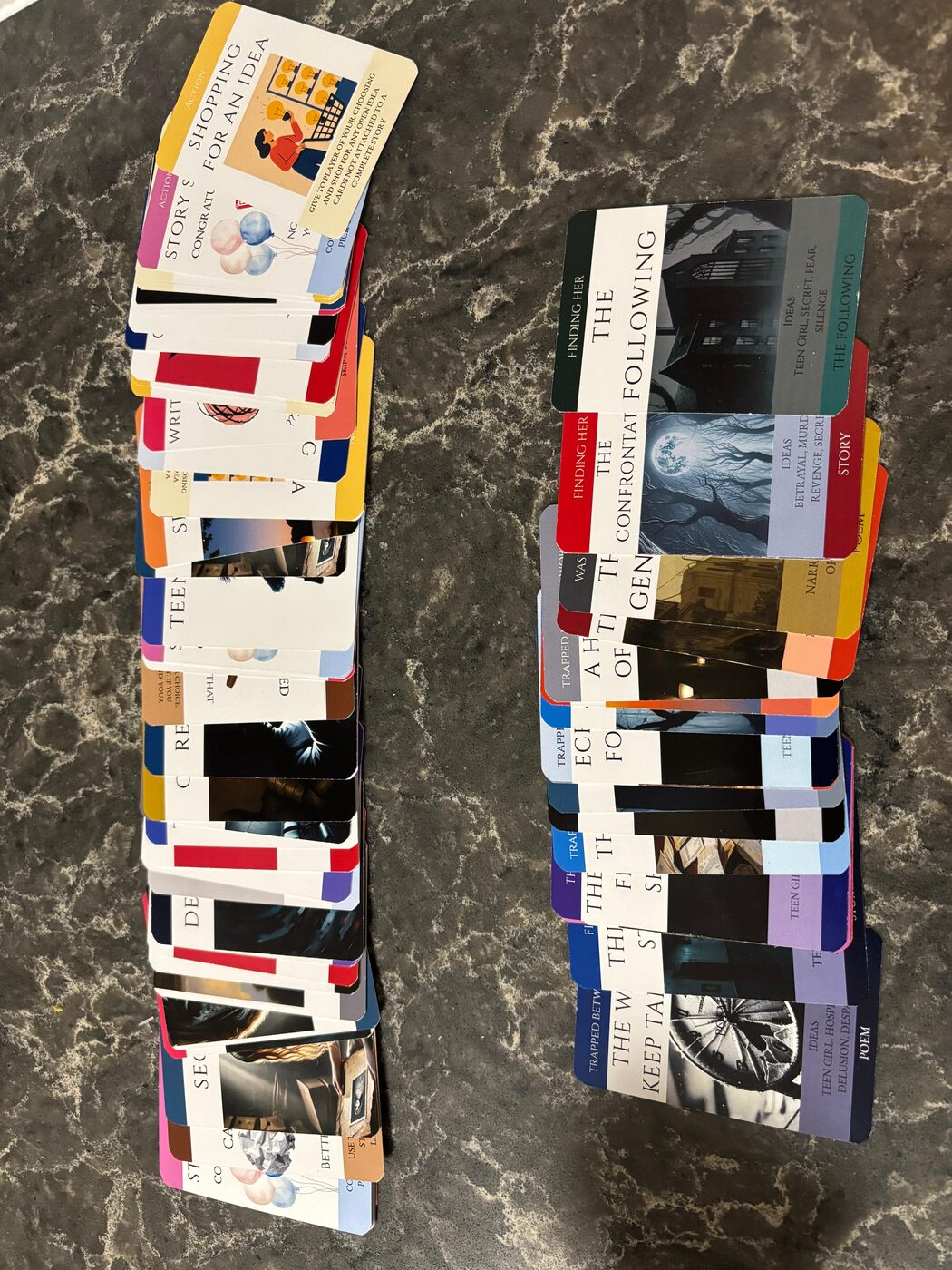 Both Writing Forever Darkness card decks fanned out, showing story and idea cards
