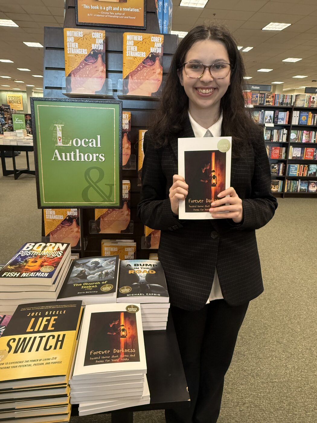 Ma'ayan with a signed copy of Forever Darkness at the Local Authors display