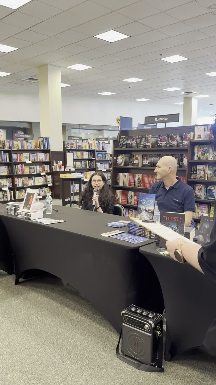 Ma'ayan speaking on an author panel with a microphone
