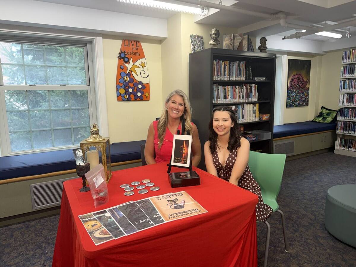 Ma'ayan and a WTNH Channel 8 reporter at the Forever Darkness table, set up for the interview