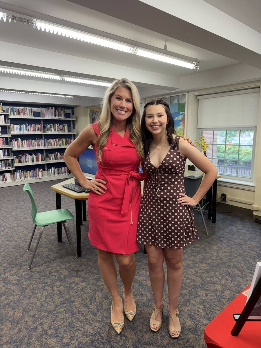 Ma'ayan standing with the WTNH Channel 8 reporter in the school library